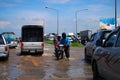 Thai people riding motorcycle and driving car on street while water flood or inundation road with vehicle busy jam traffic highway Royalty Free Stock Photo