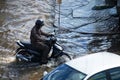 Thai people riding motorcycle and driving car on street while water flood or inundation road with vehicle busy jam traffic highway Royalty Free Stock Photo