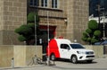 A Thai post-office vehicle waits outside a building