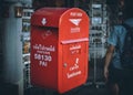 A Thai red post box at the entrance of a Thai letter film store