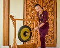 Thai restaurant waitress hitting the gong near entrance