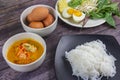 Thai rice noodles in grab curry sauce with vegetable and boiled eggs on wood table Royalty Free Stock Photo