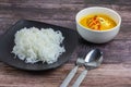 Thai rice noodles in grab curry sauce with vegetable and boiled eggs on wood table Royalty Free Stock Photo