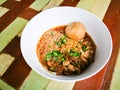 Thai Rice vermicelli noodles soup with beef and one big beef ball in white bowl on wooden table. Royalty Free Stock Photo