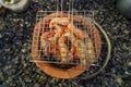 Thai river prawns grilled over charcoal grill Grilled on a BBQ Thai iron grill . Giant grilled lobster cook on charcoal stove at