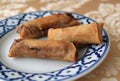 Thai rolls in a white and blue decorated plate