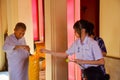 Thai schoolgirl helping a nun lighting giant c