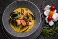 Thai soup with seafood, shrimp, salmon. Served in a gray deep stone plate