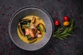 Thai soup with seafood, shrimp, salmon. Served in a gray deep stone plate