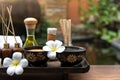 Thai spa composition treatments aroma therapy with candles and Plumeria flowers on wooden table close up. Royalty Free Stock Photo