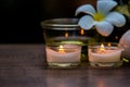 Thai spa composition treatments aroma therapy with candles and Plumeria flowers on wooden table