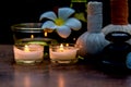 Thai spa composition treatments aroma therapy with candles and Plumeria flowers on wooden table close up.