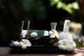 Thai spa composition treatments aroma therapy with candles and Plumeria flowers on wooden table close up. Royalty Free Stock Photo