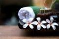 Thai spa composition treatments aroma therapy with candles and Plumeria flowers on wooden table close up. Royalty Free Stock Photo