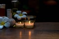 Thai spa composition treatments aroma therapy with candles and Plumeria flowers on wooden table close up. Royalty Free Stock Photo