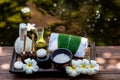 Thai spa composition treatments aroma therapy with candles and Plumeria flowers on wooden table close up. Royalty Free Stock Photo