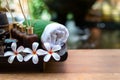 Thai spa composition treatments aroma therapy with candles and Plumeria flowers on wooden table close up. Royalty Free Stock Photo