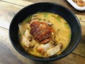 Thai spicy noodle soup topped with roasted duck and crispy pork. Royalty Free Stock Photo