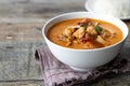 Thai spicy soup Tom yum with seafood and rice in a white plate on a wooden background. Selective focus. Royalty Free Stock Photo