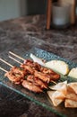 Thai spicy tender pork barbecue skewers with grill pineapple and Papadum crispy chips in glass plate Royalty Free Stock Photo