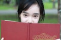 Thai student teen beautiful girl read a book sitting in park. Royalty Free Stock Photo