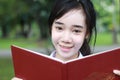 Thai student teen beautiful girl read a book sitting in park. Royalty Free Stock Photo