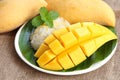 Thai style dessert, mango with glutinious rice on burlap background