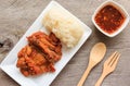 Thai style fried chicken with Red Spicy Sauce and Sticky rice on wooden table Royalty Free Stock Photo