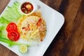 Thai style Shrimp Fried Rice Recipe Top view served on wooden table with vegetable decoration on white dish