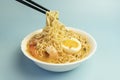 Thai style spicy soup and noodle topped with shrimps, called Tom Yum Goong on bowl with chopsticks, made with Mama Royalty Free Stock Photo