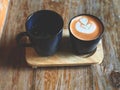 Thai tea latte art and hot drink in Black cup on wooden tray Royalty Free Stock Photo