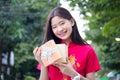 Thai teen beautiful girl in Chinese dress, happy new year and give gift, relax and smile. Royalty Free Stock Photo