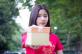 Thai teen beautiful girl in Chinese dress, happy new year and give gift, relax and smile. Royalty Free Stock Photo