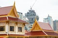 Thai temple in front of urban construction. Representative between religion and urban civilization; building and construction are Royalty Free Stock Photo