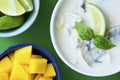 Thai Tom Kha Gai soup with mango and lime on green table Royalty Free Stock Photo