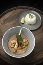 Thai tom yam kung spicy soup with prawns on wood table