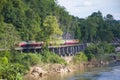 Thai trains running on death railways crossing kwai river in Kanchanaburi