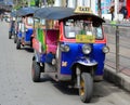 Thai tuk tuks sit parked awaiting tourists