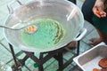 Thai vendor cooking deep fried fish paste ball in a big pan