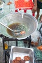 Thai vendor cooking deep fried fish paste ball in a big pan