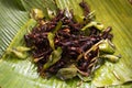 Thai vendor merchant cooked local exotic cuisine bug and herbal or food fried insect with herb at stall hawker for sale traveler Royalty Free Stock Photo