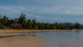 Thai village on the beach at sunset with houses surrounded by palm trees Royalty Free Stock Photo