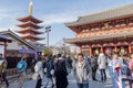 Thai woan is taking photo in front of Asakusa entrance and pagoda with a flock of Japanese people behind. Tokyo, Japan February 7
