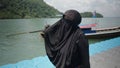 Thai woman covering head and face with yashmak walking on floating plastic pier at Railay Beach, Thailand travel tour -