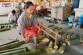 Thai woman cuts bamboo trunks at the traditional umbrella factory in Chiang Mai, Thailand.