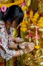 Thai Woman glid cover angel statue with gold leaf at Phra Kal Sh Royalty Free Stock Photo