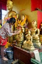 Thai Woman glid cover angel statue with gold leaf at Phra Kal Sh