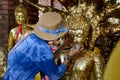 Thai Woman glid cover Buddha statue with gold leaf at Wat Yai ch