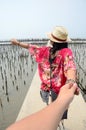 Thai woman lead someone by the hand and hold on the walkway bridge