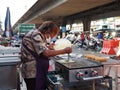 Thai woman makes sausage crepes at a local market